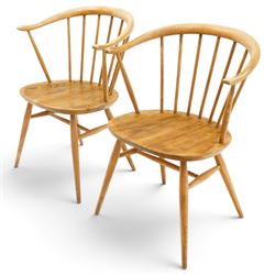 Ercol - pair of 'Cowhorn' elm carver chairs, curved back raised on nine stretchers, elm dished seats, raised on tapering supports