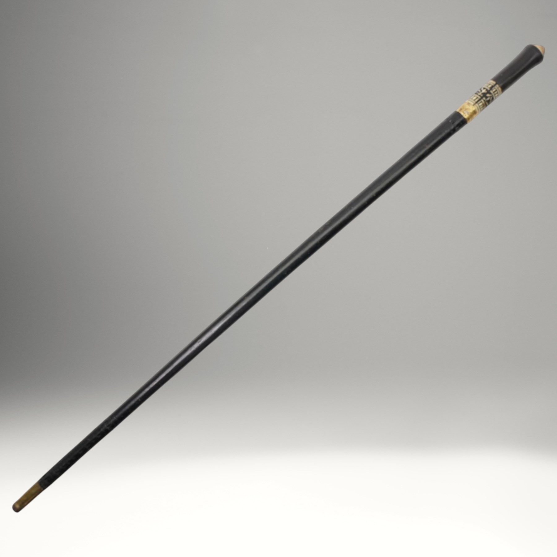 Early 20th century Indian concealed sword-stick, the black wooden scabbard and grip with carved bone collar, engraved brass band, and brass pommel in the form of a tigers head, W92cm
