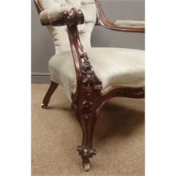  Victorian walnut open armchair, cresting rail carved and pierced with floral and scrolled leaf decoration, down swept arms with scroll terminals, arm supports and cabriole feet with flower head carvings, upholstered in buttoned velvet, wide serpentine seat, W68cm  