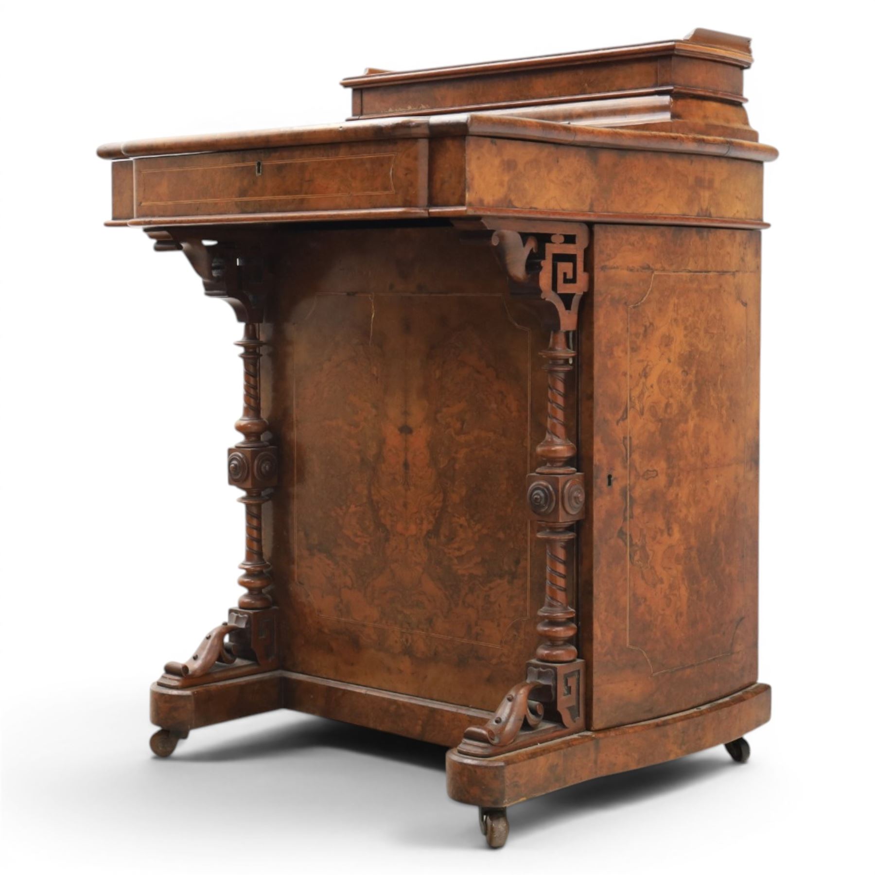 Victorian burr walnut Davenport, with hinged stationary top and slope, pull out writing surface with tooled green leather inset top, carved and turned front supports, flanked by two cupboard doors, raised on castors 