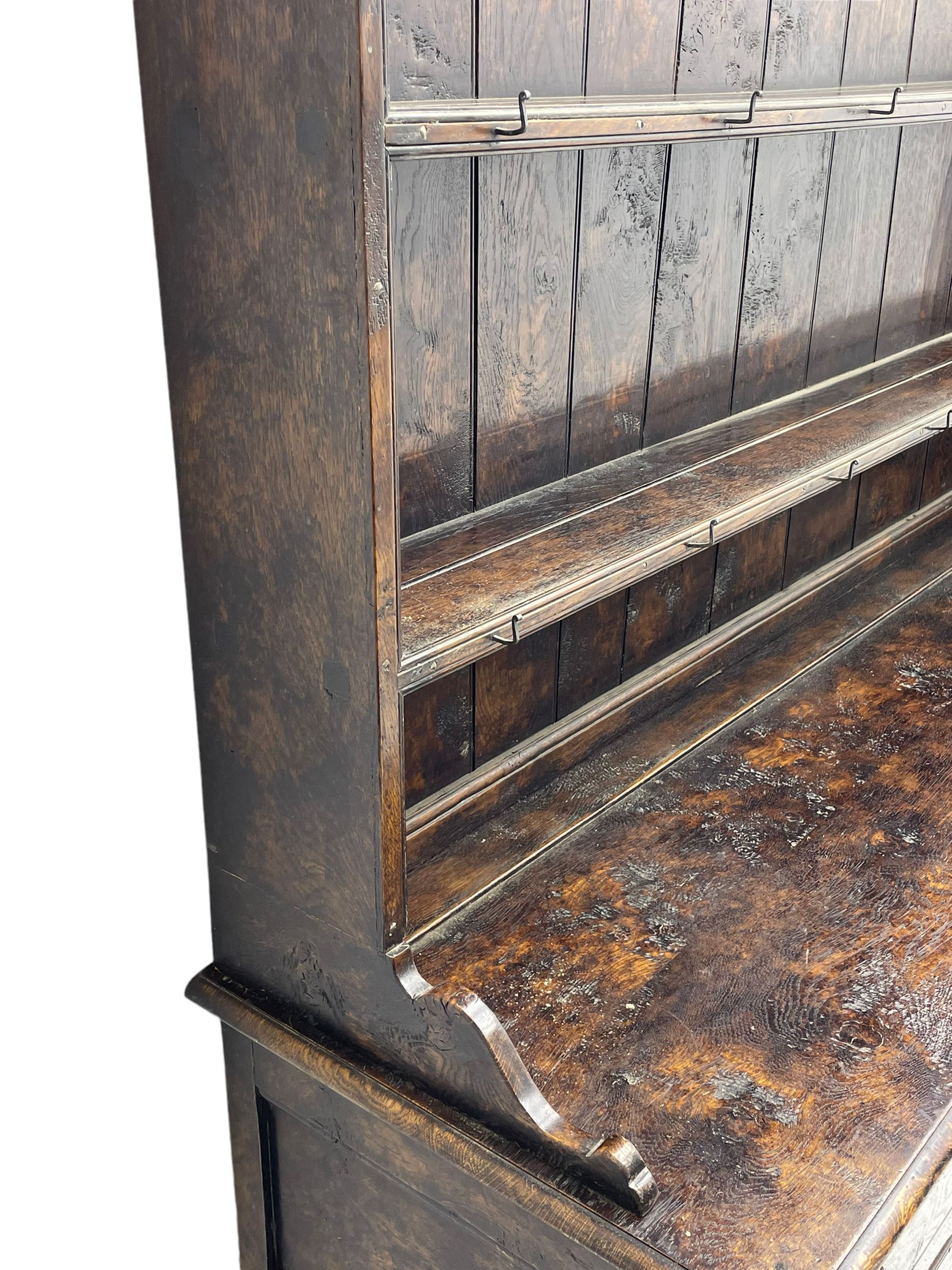 Bylaws of Leominster - 18th century design figured oak dog kennel dresser, the raised plate rack with projecting cornice over hooks and three tiers, moulded rectangular top over three drawers and two panelled cupboards, moulded frame and panelled sides, on stile supports
