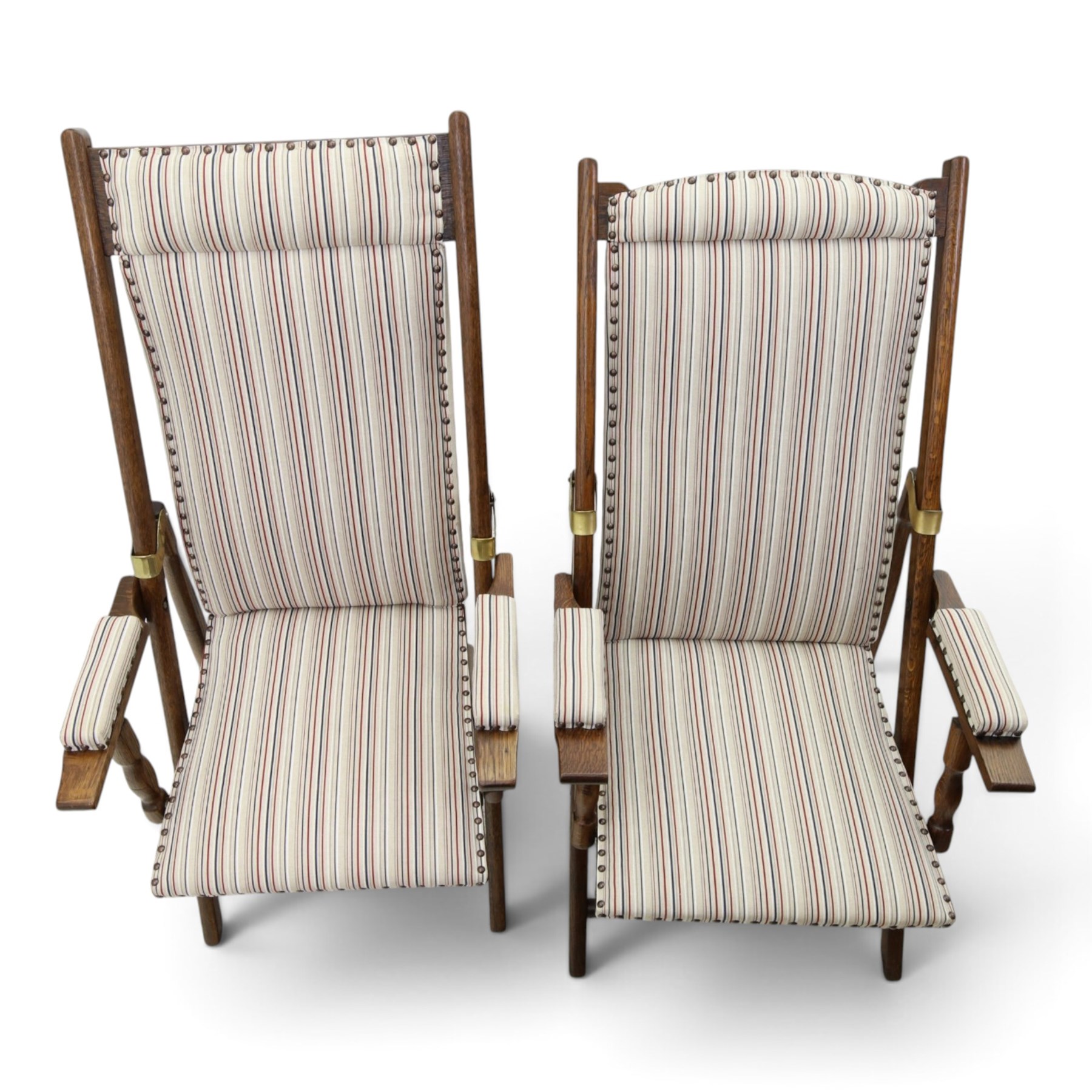 Pair of early 20th century oak framed garden reclining and folding deckchairs, high back and seat upholstered in striped fabric with padded armrests