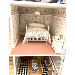 Georgian style wooden double fronted three-storey dolls house with pale blue stucco finish under a faux tiled roof with two chimney stacks, the double hinged front opening to reveal six fully decorated rooms with floor coverings, central staircase, porcelain fitted bathroom, kitchen with deep white sink and Aga cooker, electric lighting with adaptor, fully furnished with French style and other furniture, grand piano etc, and comprehensive range of accessories H82cm W61cm D31cm