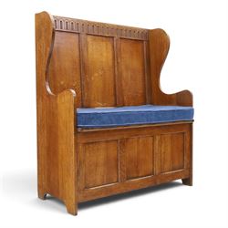 Early 20th century oak box settle, panelled back with arcaded carved rail, swept sides and arms, hinged seat with storage, panelled front