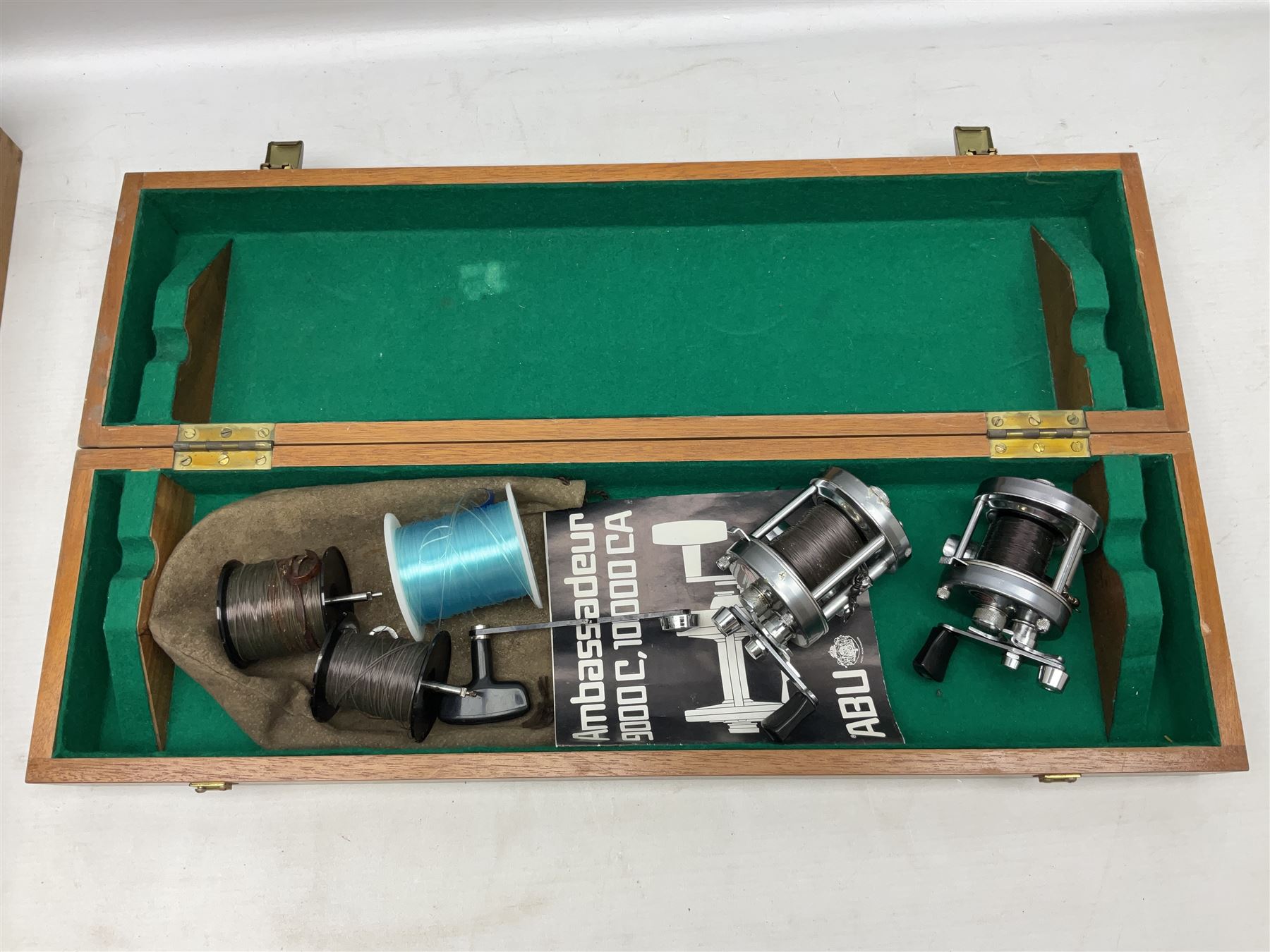 Four Abu fishing reels, comprising Ambassadeur 9000, Ambassadeur 7000, Ambassadeur 5500 and Ambassadeur 6500, together with additional line, hardy fishing bag and two wooden boxes