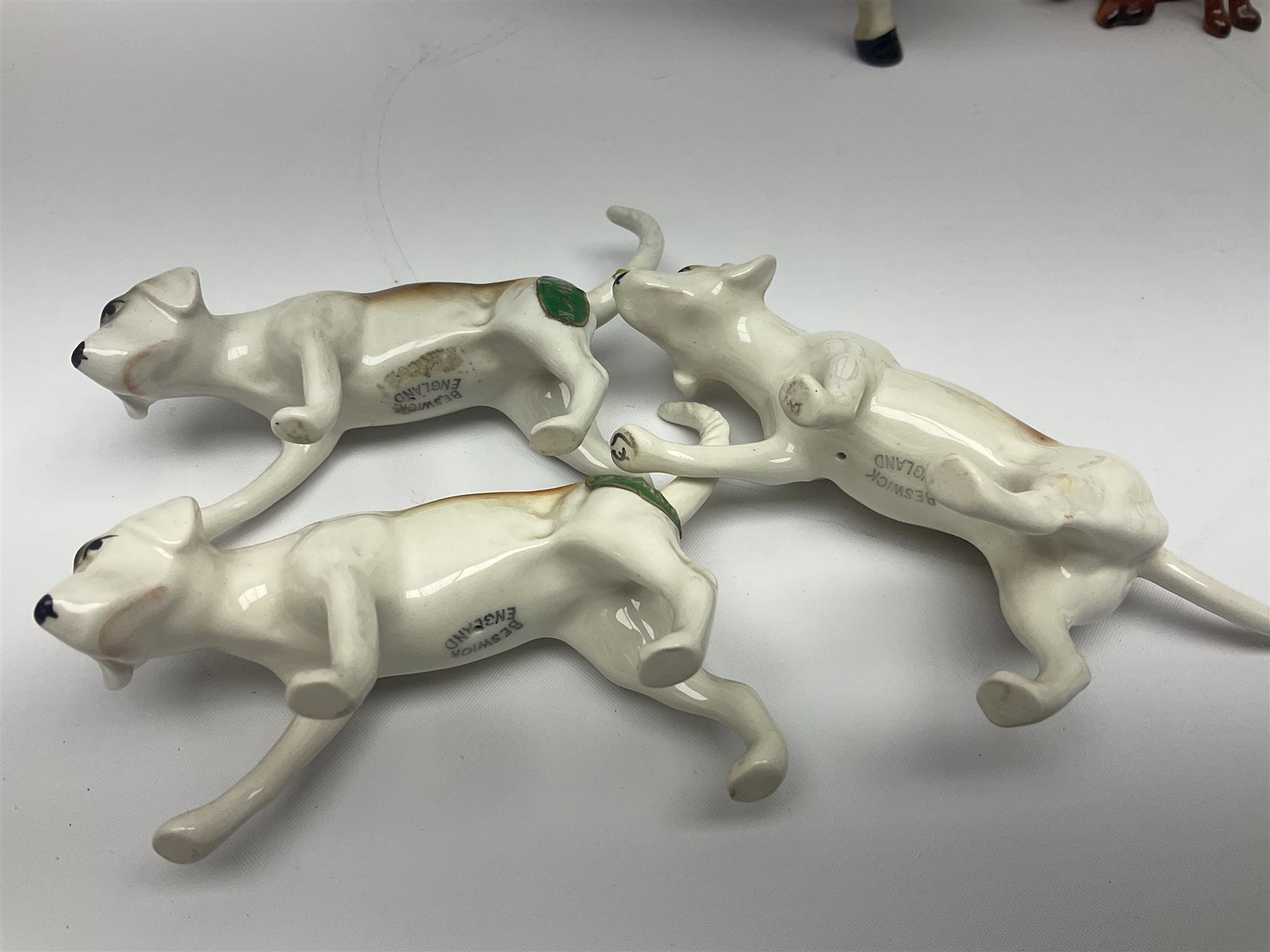 Beswick hunting group, comprising huntswoman on dappled grey horse no 1730, huntsman on bay horse no 1501, two fox figures no 1440 and 1748, and four fox hounds, all with printed marks beneath (8)