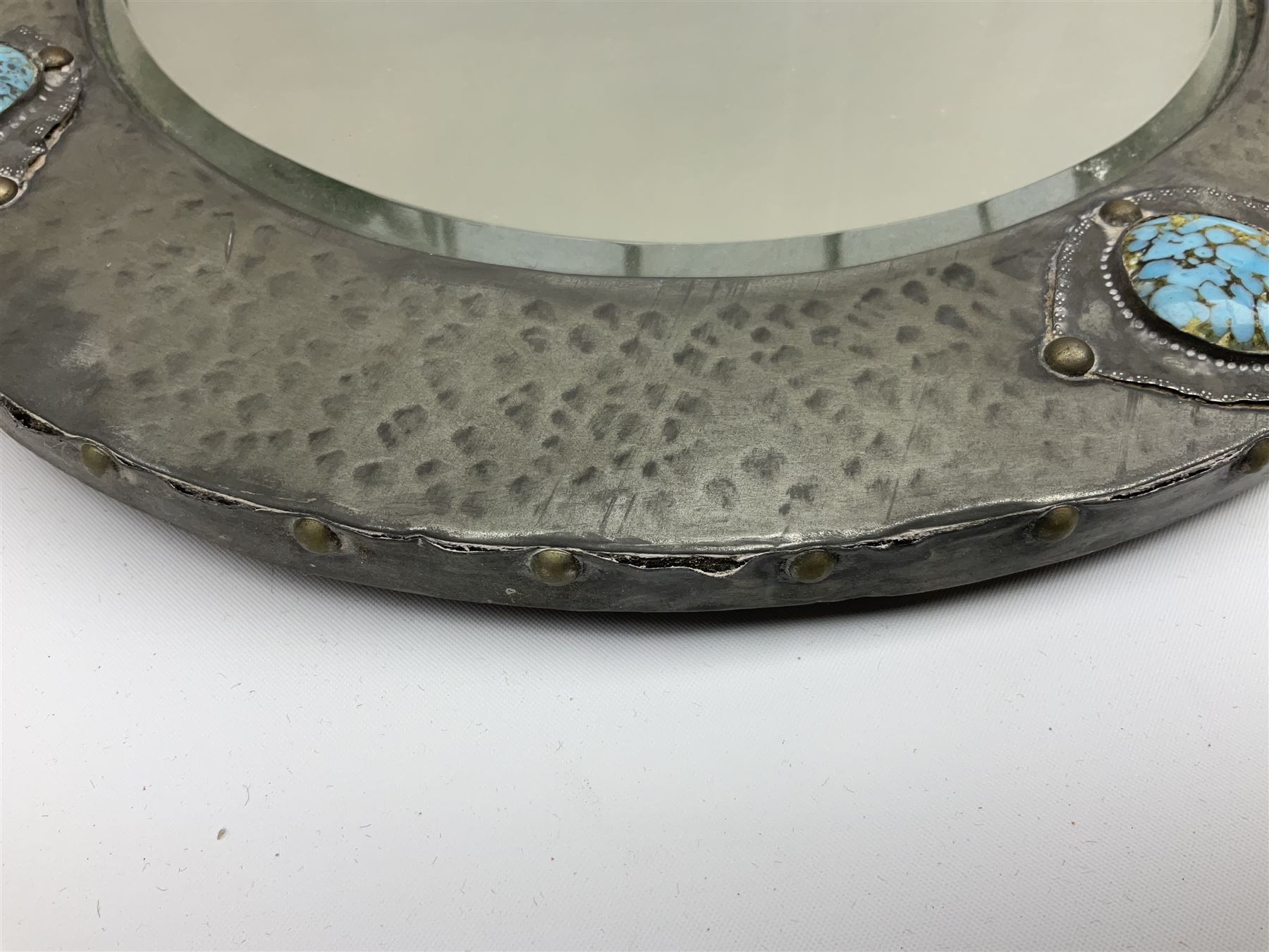 Arts & Crafts style circular hammered pewter mirror inset with four turquoise cabochons, D27.5cm