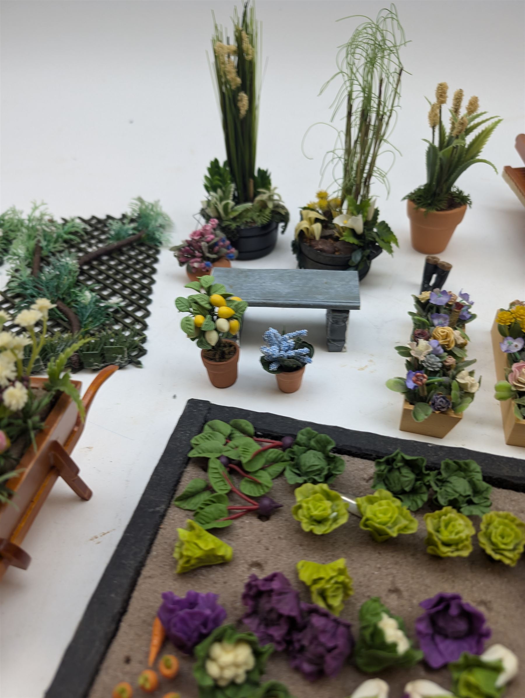 1:12 scale dolls house allotment and garden accessories, including wooden shed on a stone effect base, two vegetable patches, terracotta plant pots with flowers and foliage, stone effect plant pots, other planters, loose sunflowers, scarecrow, rabbit hutch, garden tools, fencing panels, etc 