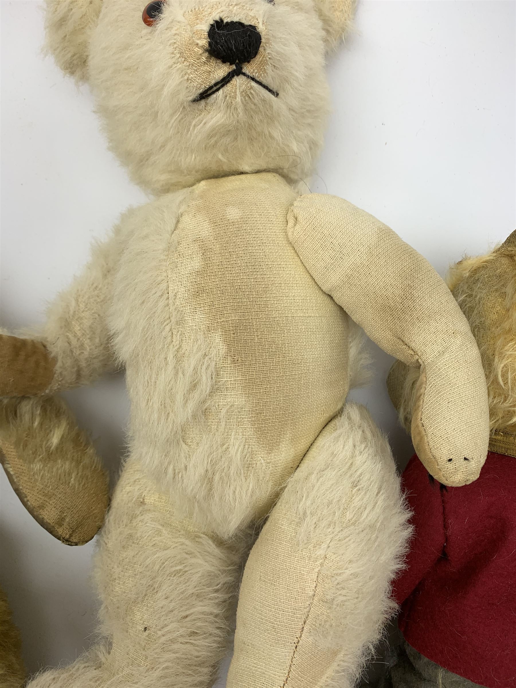 Four Chiltern teddy bears 1930s-50s, including white one with revolving head, glass type eyes, vertically stitched nose and mouth and jointed limbs with felt paw pads H16.5