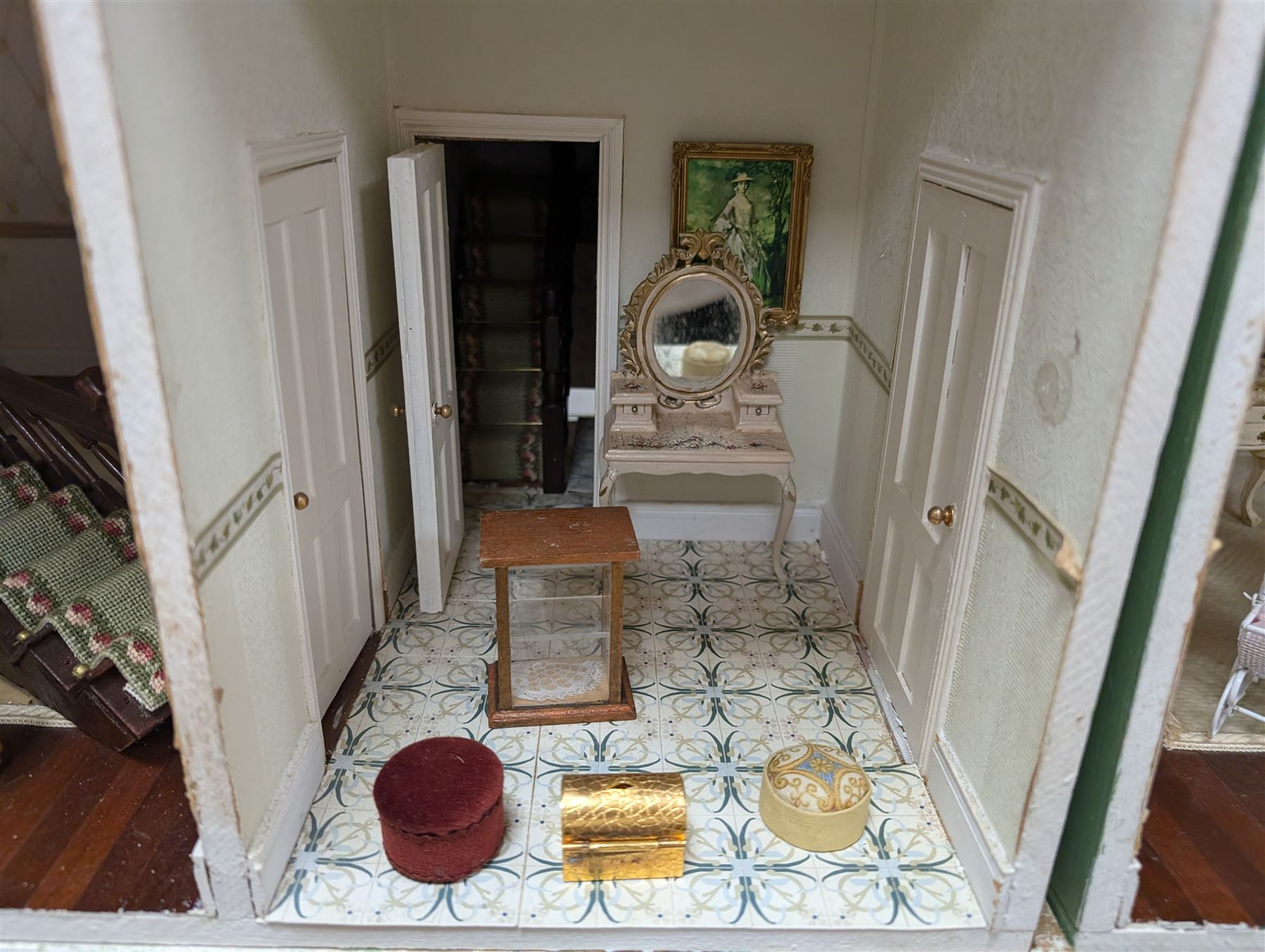 Two modern three storey dolls houses, each painted green with decorated interiors, both upon a single white wooden base, together with a large collection of dolls house furniture, accessories and figures 