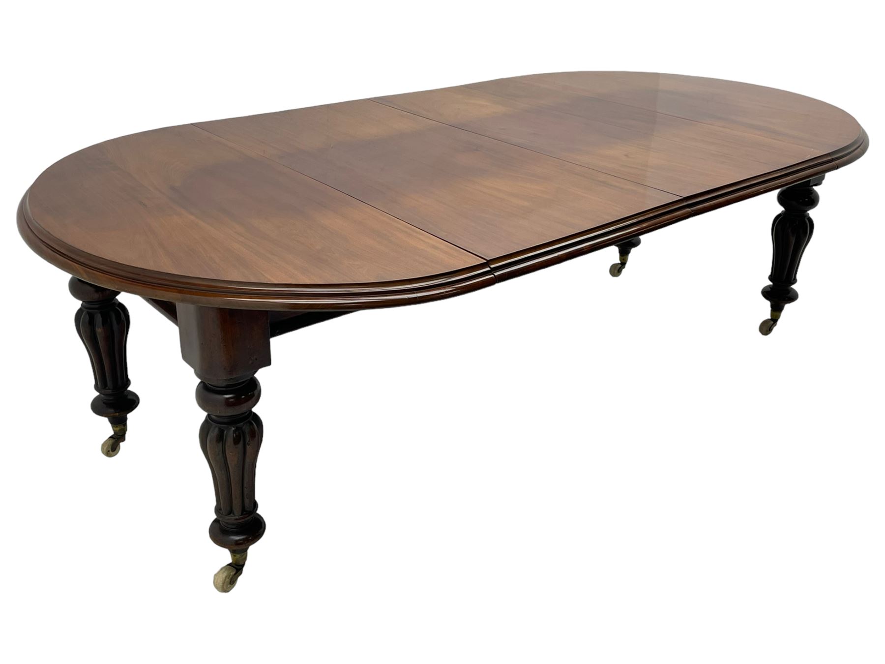Victorian mahogany extending dining table, circular telescopic extending top with moulded edge, two additional leaves, on turned and lobe carved supports with brass and ceramic castors 