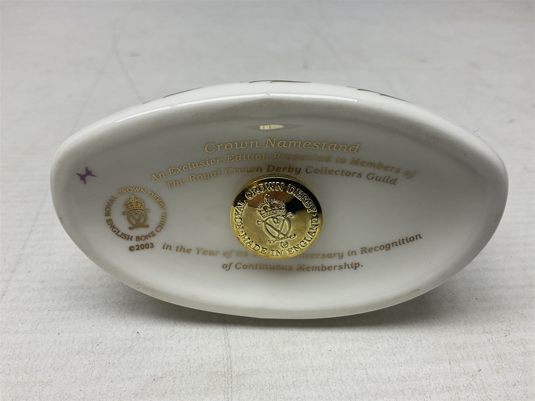 Four Royal Crown Derby teddy paperweights, comprising Teddy Cook, two Teddy George and Seated Teddy, all without stoppers, together with Crown Namestake with gold stopper 