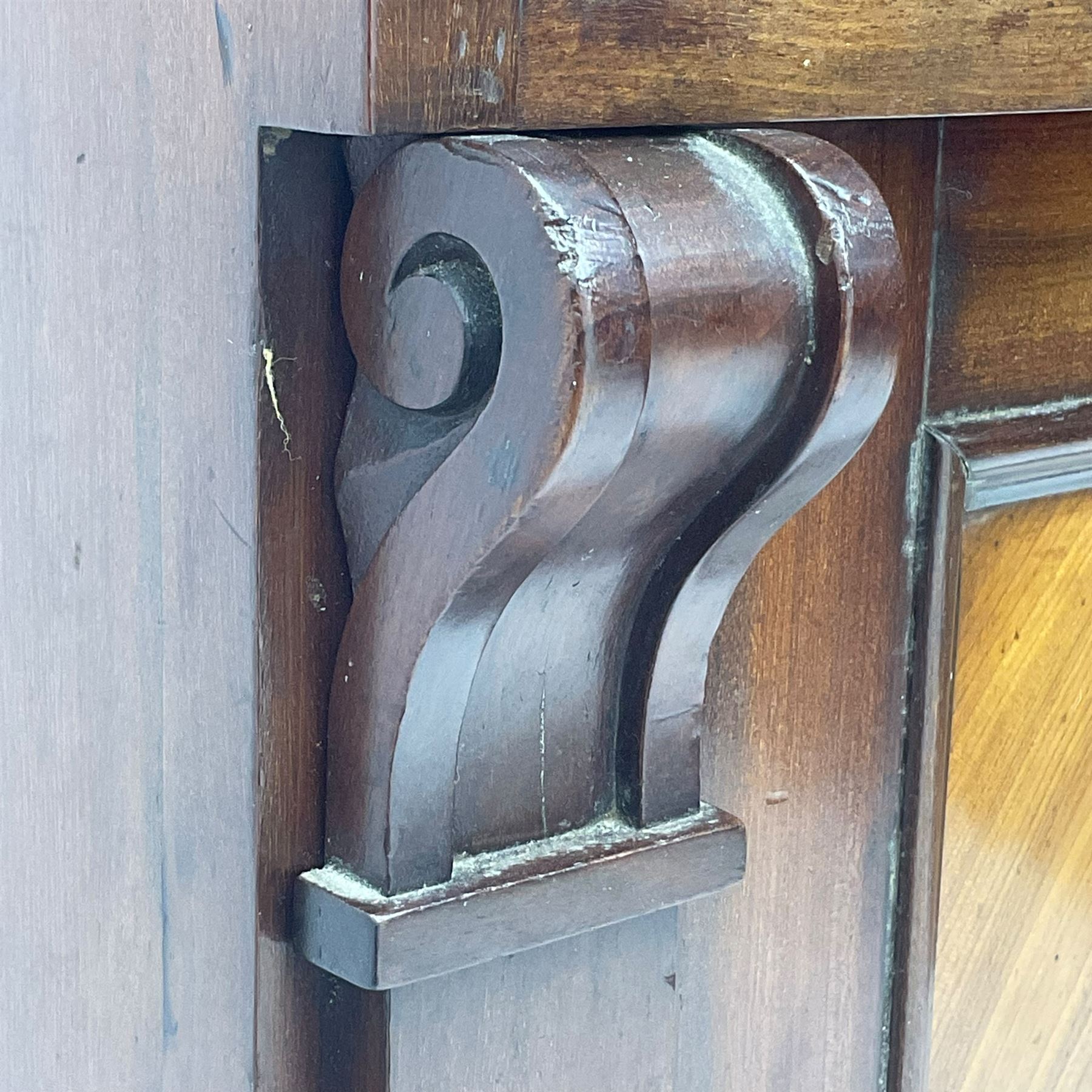 Early 19th century figured mahogany bureau bookcase, projecting splay moulded cornice over three adjustable shelves enclosed by two glazed doors, fall front revealing pigeonholes, cupboard and drawers, pull-out strays with scroll carved terminals, double cupboard with two panelled doors, on turned feet 