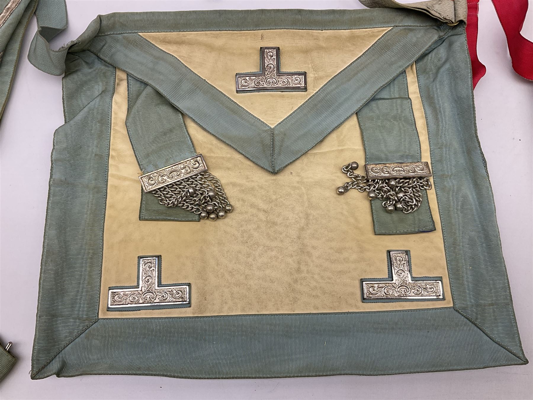 Two Masonic kid leather aprons, one with sash and cuffs, the other with sash, each marked 'Yorkshire North and East Ridings'; and three other unmarked Masonic aprons with sashes
