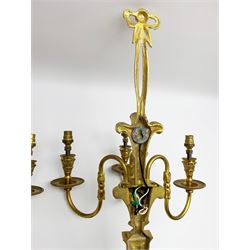 Pair of 20th century gilt metal Louis XVI style wall sconces, each with three curved branches rising from tapering backplates with husk swag and plume detail, and ribbon tied surmounts, H63cm W36cm