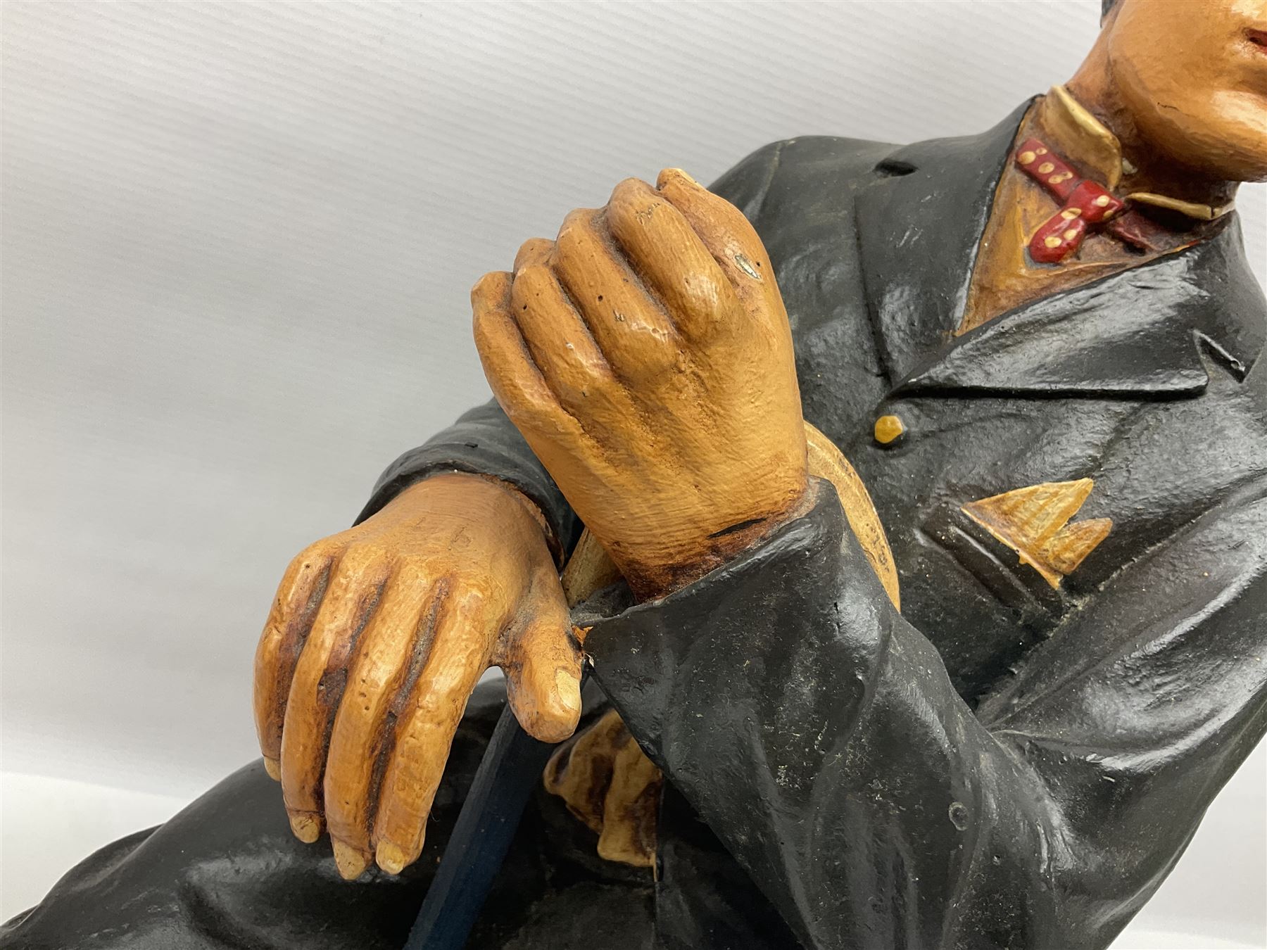 Large painted composite figure of Charlie Chaplin, seated upon wooden chair, H54cm