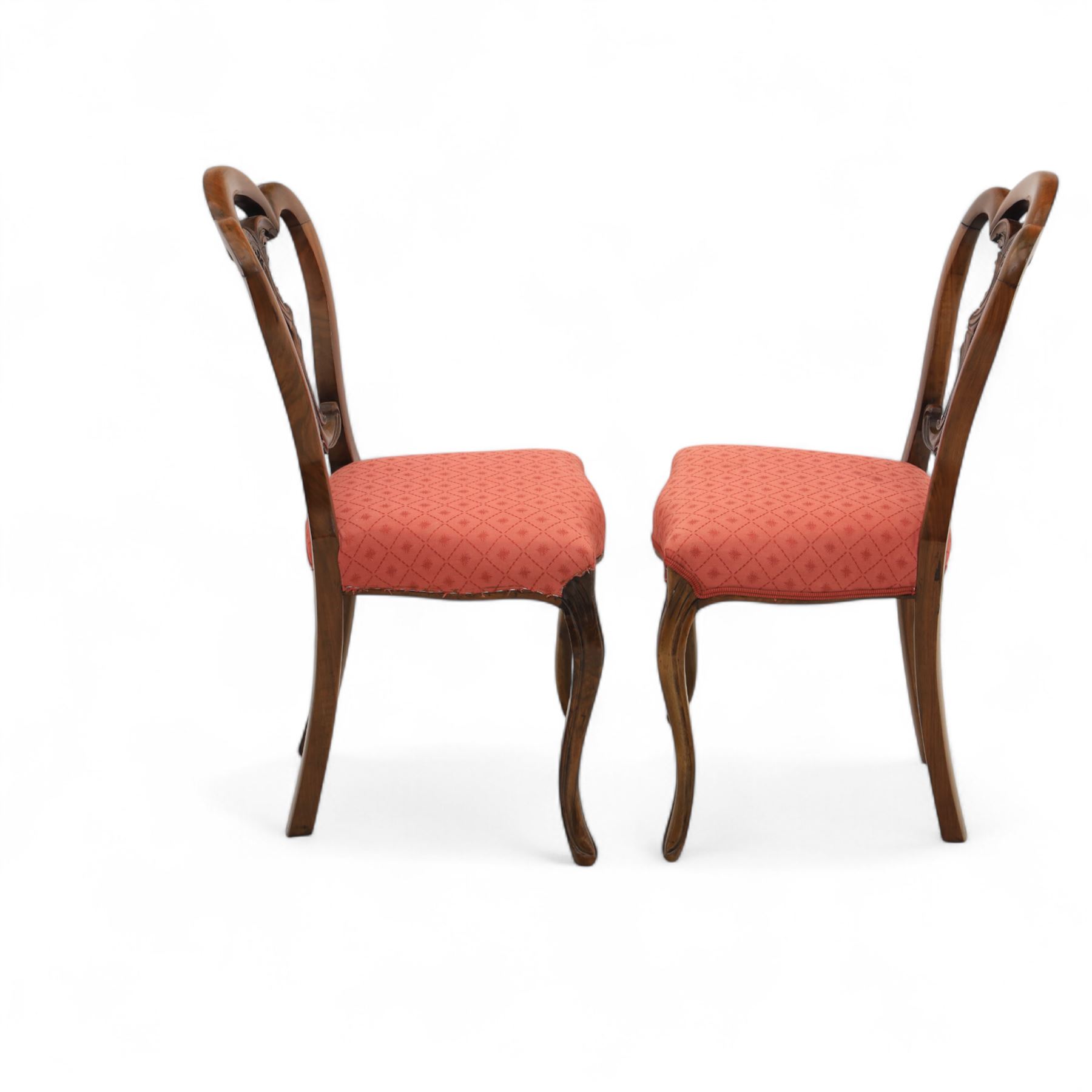 Set of four Victorian walnut balloon back chairs, with a carved and pierced back splat with foliate scrolls, serpentine seat upholstered in a diamond pattern fabric, raised on cabriole legs 