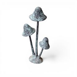 Bronze garden ornament in the form of three mushroom stalks, on naturalistic base