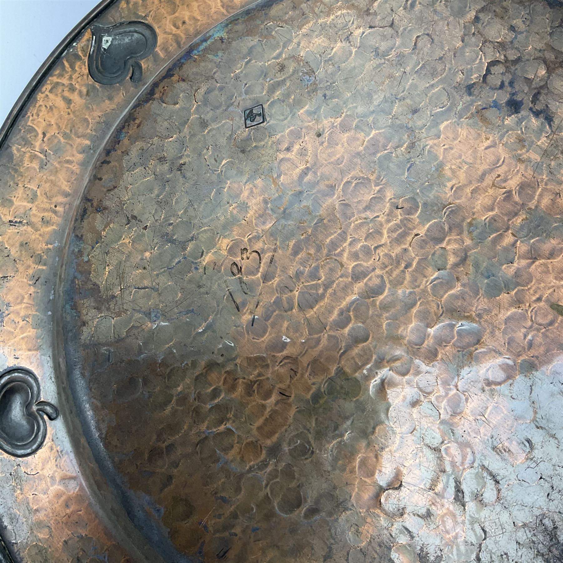 An early 20th century WMF Art Nouveau style copper plate, decorated to the rim with heart shaped motifs, with ostrich mark beneath, D30cm. 