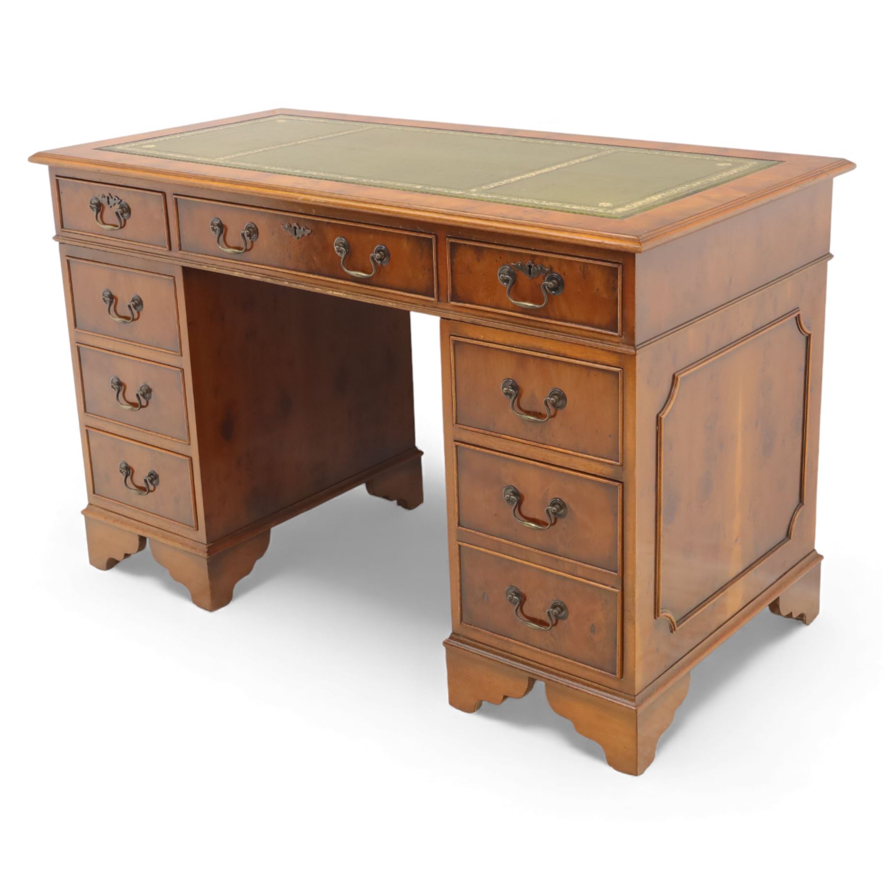 Late 20th century yew wood nine drawer writing desk, rectangular top inset with gilt-tooled green leather, above an arrangement of nine drawers with brass swan-neck handles, raised on bracket feet
