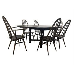 Ercol - 'Old Colonial' 705 elm extending dining table, oval top with hidden leaf, raised on turned supports united by X-stretcher (W163cm D108cm H72cm); and Ercol - set six  (4+2) dark elm 'Quaker Back Windsor Dining Chairs', hoop and stick backs 