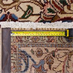 North West Persian Tabriz, hand-knotted carpet, ivory ground with dense scrolling vine-work, palmettes, flowering sprays, and stylized leaves framed by a principal border of scrolling floral motifs and palmettes and flanked by narrow guard borders, with cotton fringe ends