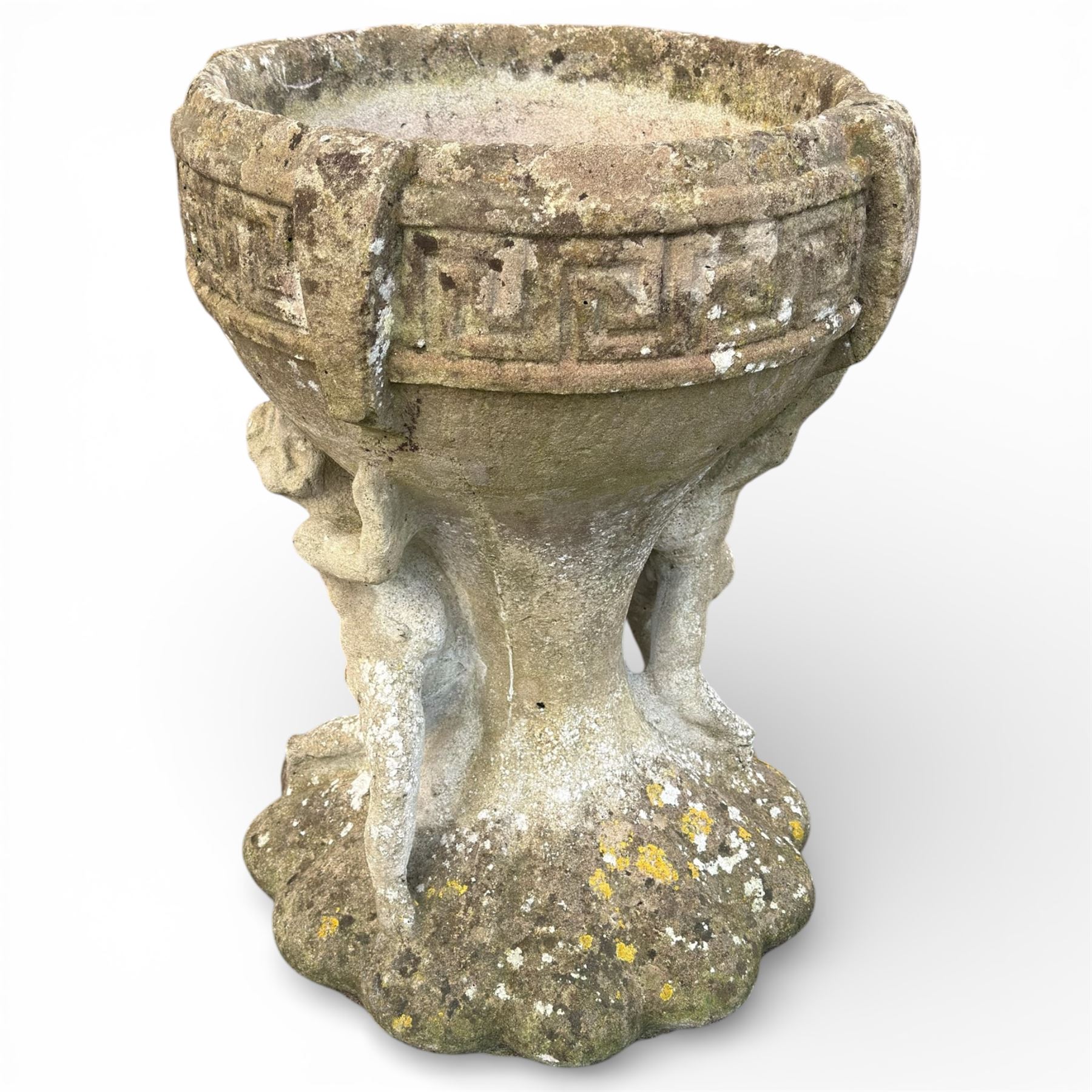 Cast stone urn with two figures supporting the bowl