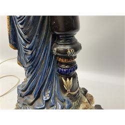 Composite table lamp modelled as a Roman Emperor donning blue robes, upon quatrefoil base modelled with rams heads and winged cherubs, H56cm excl fitting