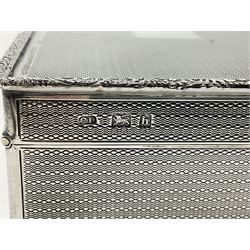 1920's silver table cigarette box, of rectangular form with engine turned decoration to the exterior, the hinged cover with central vacant rectangular panel and raised foliate rim, opening to reveal a gilt interior with later plush lining, hallmarked Charles Henry Dumenil, London 1923, H3.5cm L14.5cm D8.5cm