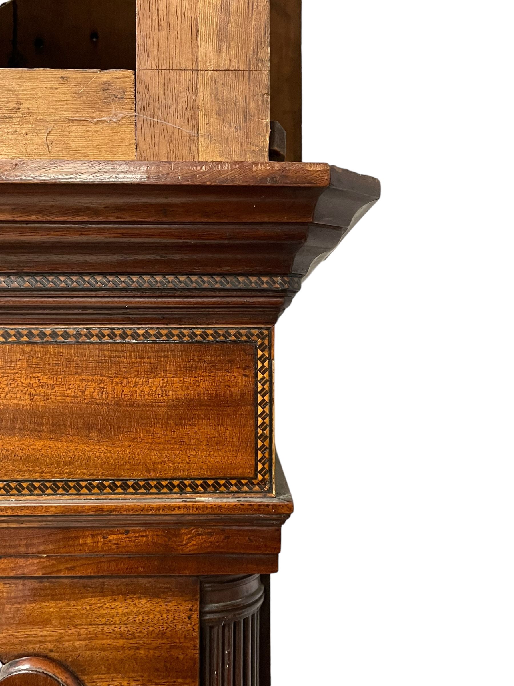 John Morgan of Aberystwyth - fine George IV mahogany 8-day longcase clock c1820, with a raised swan necked pediment, ball and eagle finial and deep inlaid frieze beneath, square hood door with a glazed circular wooden bezel and canted corners, long trunk with reeded quarter columns and a wavy topped door, rectangular plinth on bracket feet, circular painted dial with Roman numerals, minute track, makers name, and brass stamped hands, rack striking four pillar movement with a recoil anchor escapement, striking the hours on a bell. With weights and pendulum. 
John Morgan is recorded as working in Aberystwyth 1816-35. 