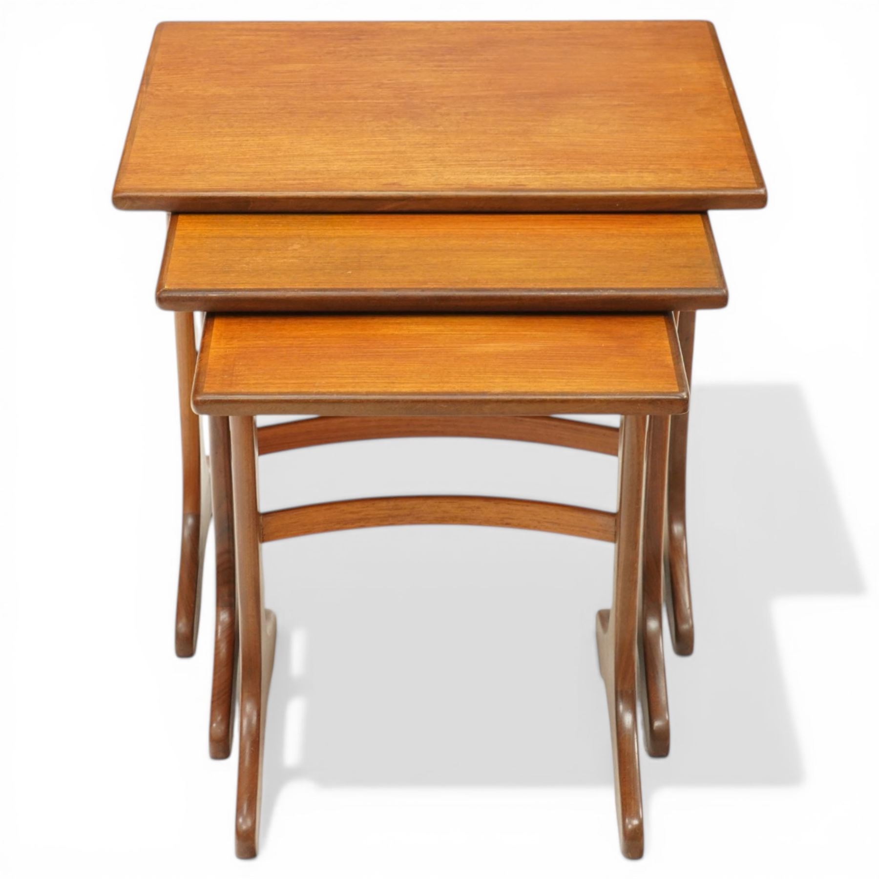 Victor Wilkins for G-Plan - 1970s teak 'Fresco' nest of three tables, rectangular top over vasiform end-supports with sledge feet, united by curved stretchers