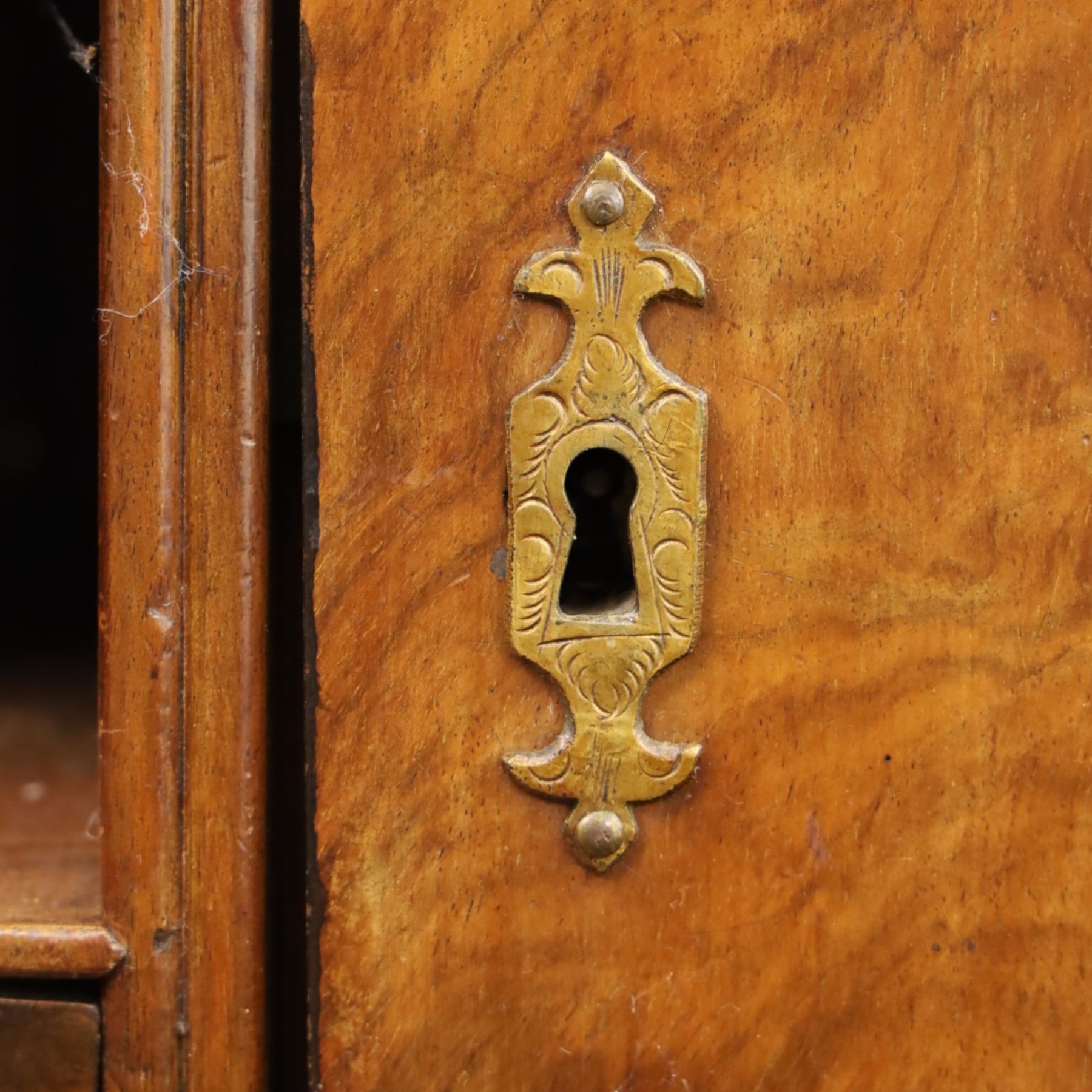 18th century figured walnut bureau, the sloped fall-front enclosing fitted interior with sliding base, pigeon-holes and correspondence drawers with shaped facias, over two short and two long feather-banded drawers with pressed brass handle plates, on bracket feet