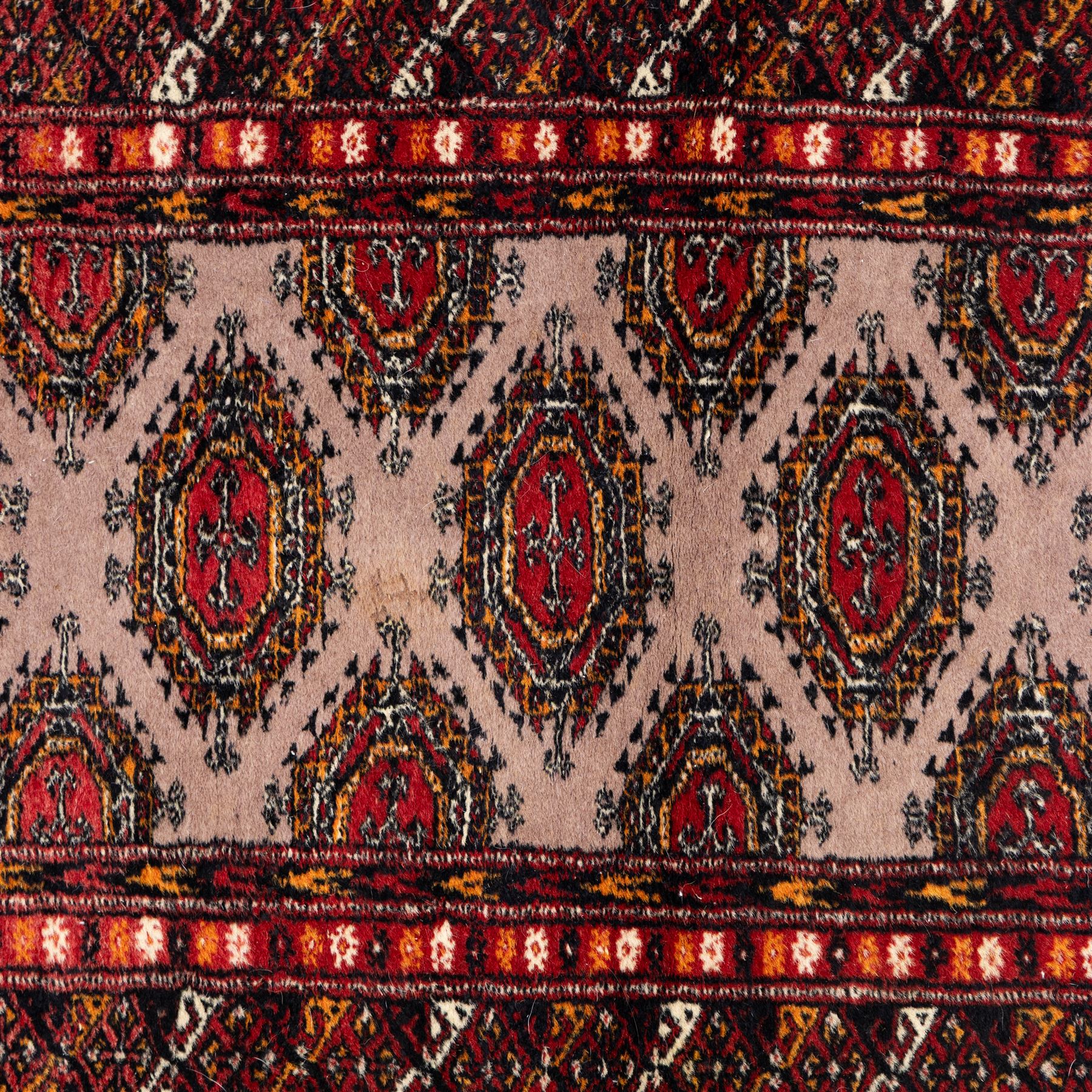 Tekke Bokhara hand knotted  runner, crimson field decorated with a series of repeating Tekke gul motifs arranged in rows within narrow geometric borders with chevron and diamond devices, 78x248cm 