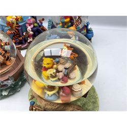 Five Disney Winnie The Pooh snow globes, to include Pooh and Piglet Sailing, Pooh's Grand Adventure and Blustery Day, together with The Walt Disney Classic Waterglobe collection globe and group Tigger, Winnie and Piglet figure under dome, all with boxes (7)