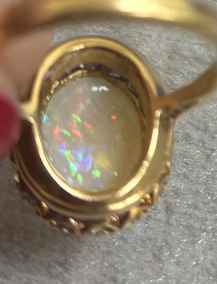 Early 20th century gold opal and diamond cluster ring, single oval cabochon opal, surrounded by sixteen old cut diamonds, stamped 18ct, total diamond weight approx 0.65 carat