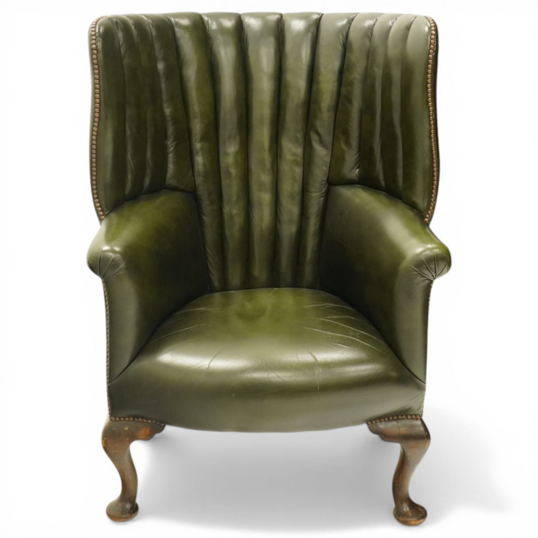 Georgian design green leather barrel-back wingback armchair, pleated upholstered back with shaped wings over scroll arms and sprung-seat, close nailed border, raised on cabriole supports terminating in pad feet