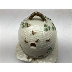 20th century Belleek beehive honey pot and cover, in the form of a bee skep raised on three legs, with black printed mark beneath 