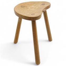 Mouseman - oak three-legged milking stool, dished kidney-shaped seat carved with mouse signature, on three octagonal tapered supports, by the workshop of Robert Thompson, Kilburn