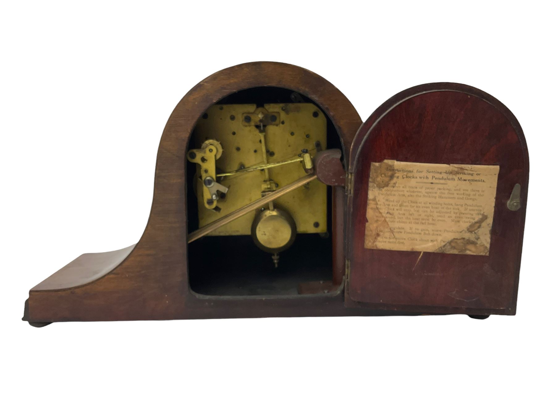 Sapele Mahogany cased tambour mantle clock c1950 with a three-train chiming movement, chiming the quarters on 5 gong rods, with a silvered dial, Arabic numerals, minute track and steel spade hands, strike/silent facility. With pendulum.



