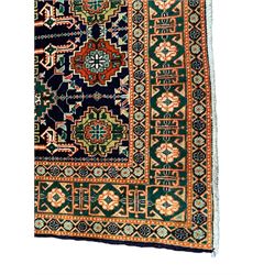 Small Persian indigo ground rug, the field decorated with Gilt motifs with trailing bead and stylised foliage, emerald green ground border decorated with geometric design and flower heads
