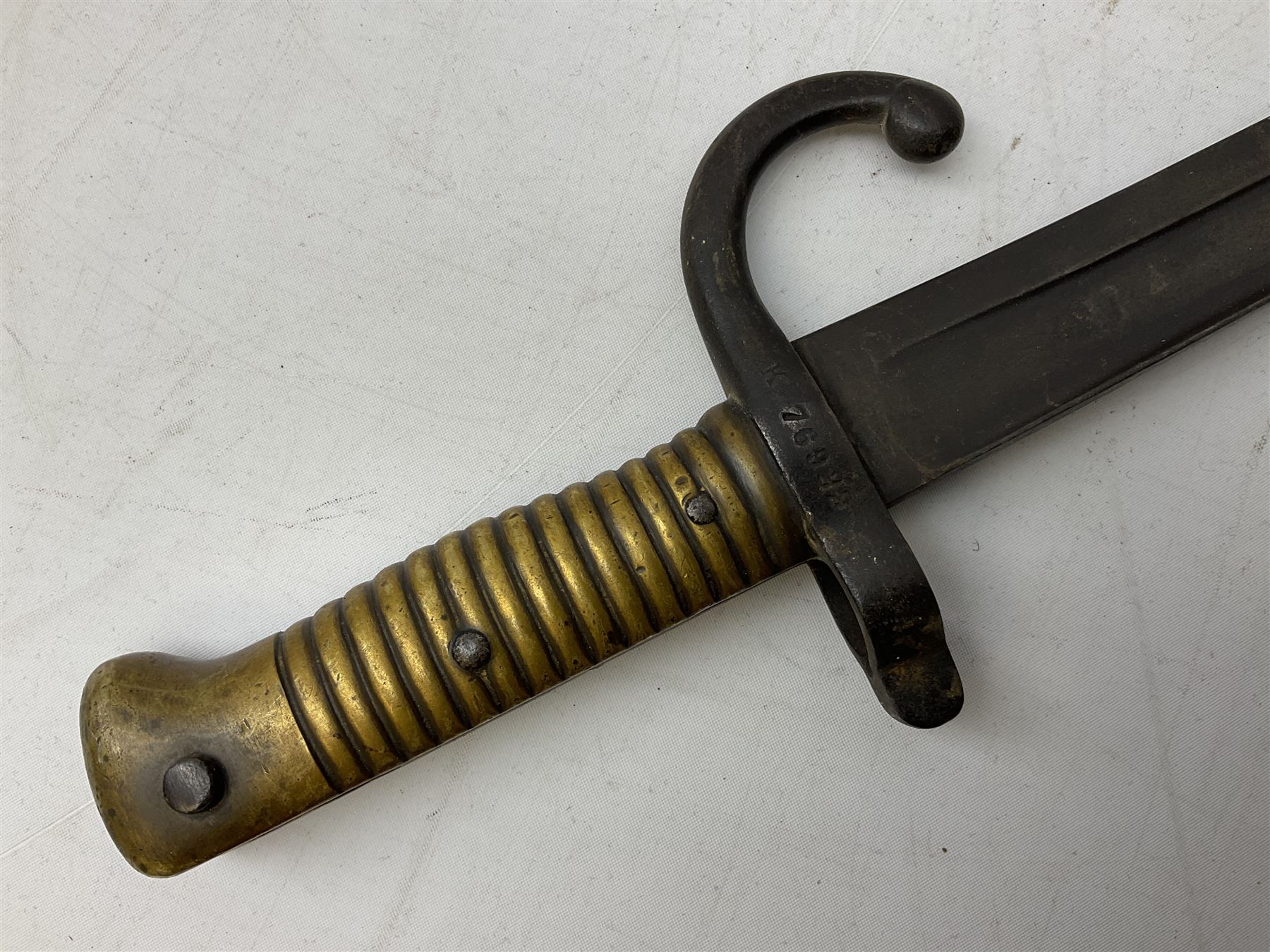 French Model 1866 sabre bayonet with 57cm fullered steel curving blade; in steel scabbard L71cm overall; another Model 1866 sabre bayonet lacking scabbard; and British Pattern 1856 sword bayonet (no scabbard) (3)