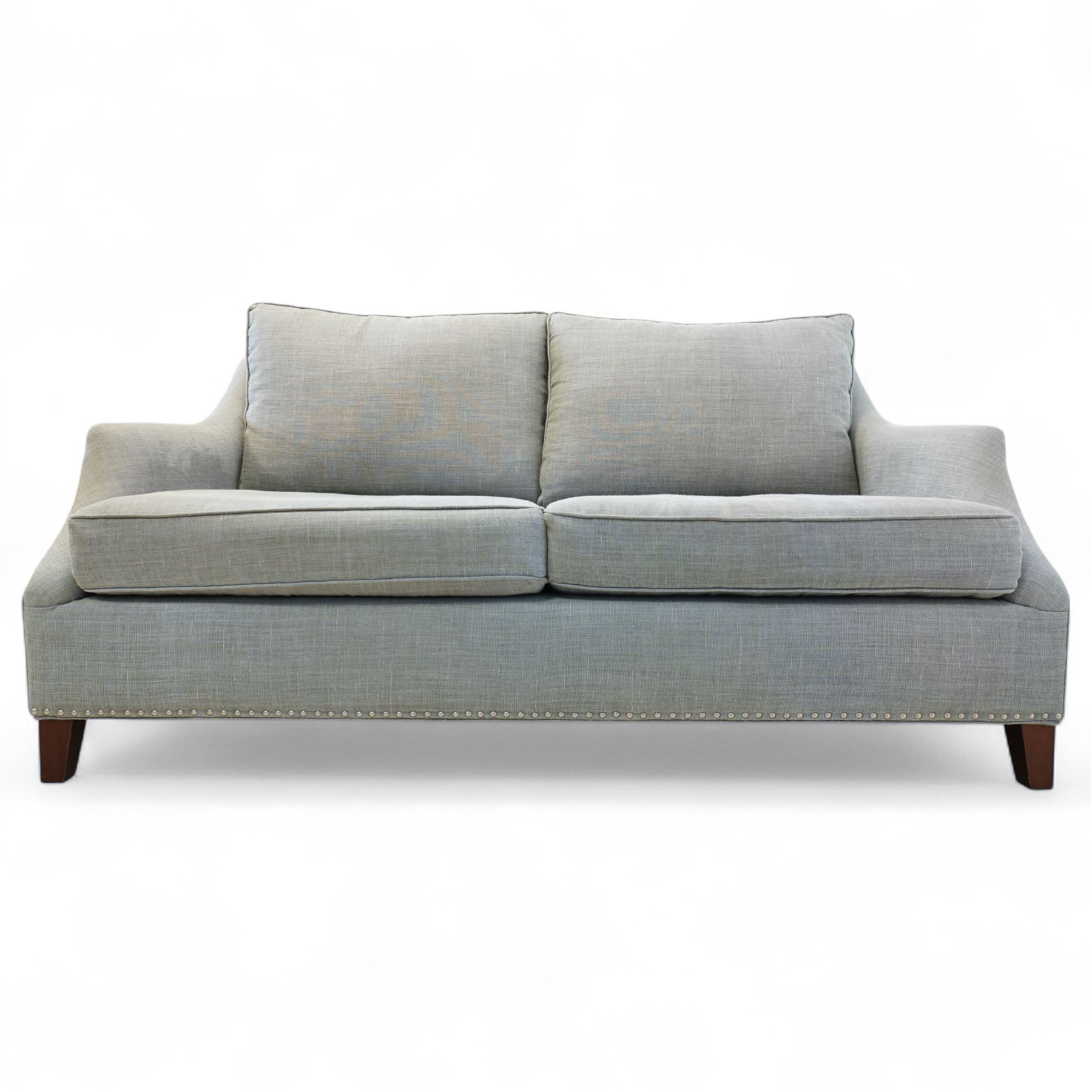 Neptune traditional style two-seat sofa, sloped back rest, gently flared arms, studded upholstered in a light grey fabric on square tapered legs 