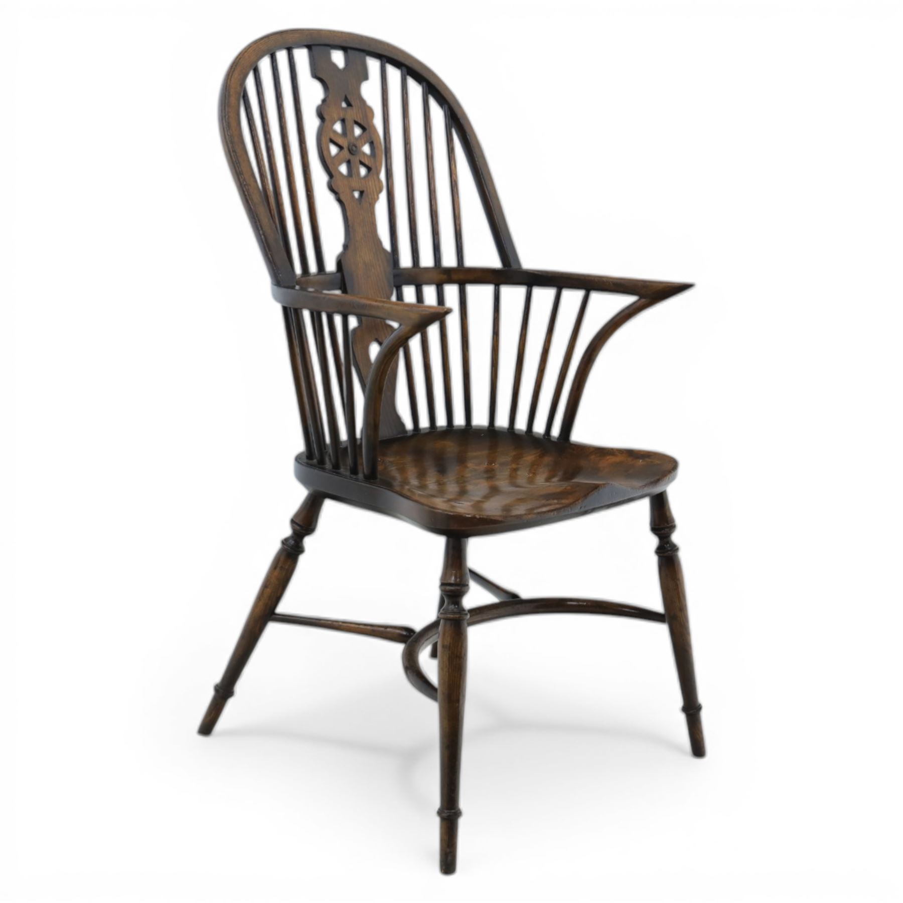 Late 19th century elm and beech high back Windsor armchair, the arched hoop back centred by a pierced wheel splat above a heart shaped lower piercing, with turned spindles and shaped arm rail, saddle seat, raised on turned legs united by a crinoline stretcher
