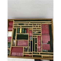Large collection of Meccano, including perforated strips, wheels, cogs, nuts and bolts, various Meccano instruction manuals and magazines, all housed within a modified wooden box, with three tiered compartmentalised sections and upon four twist legs, box H60cm