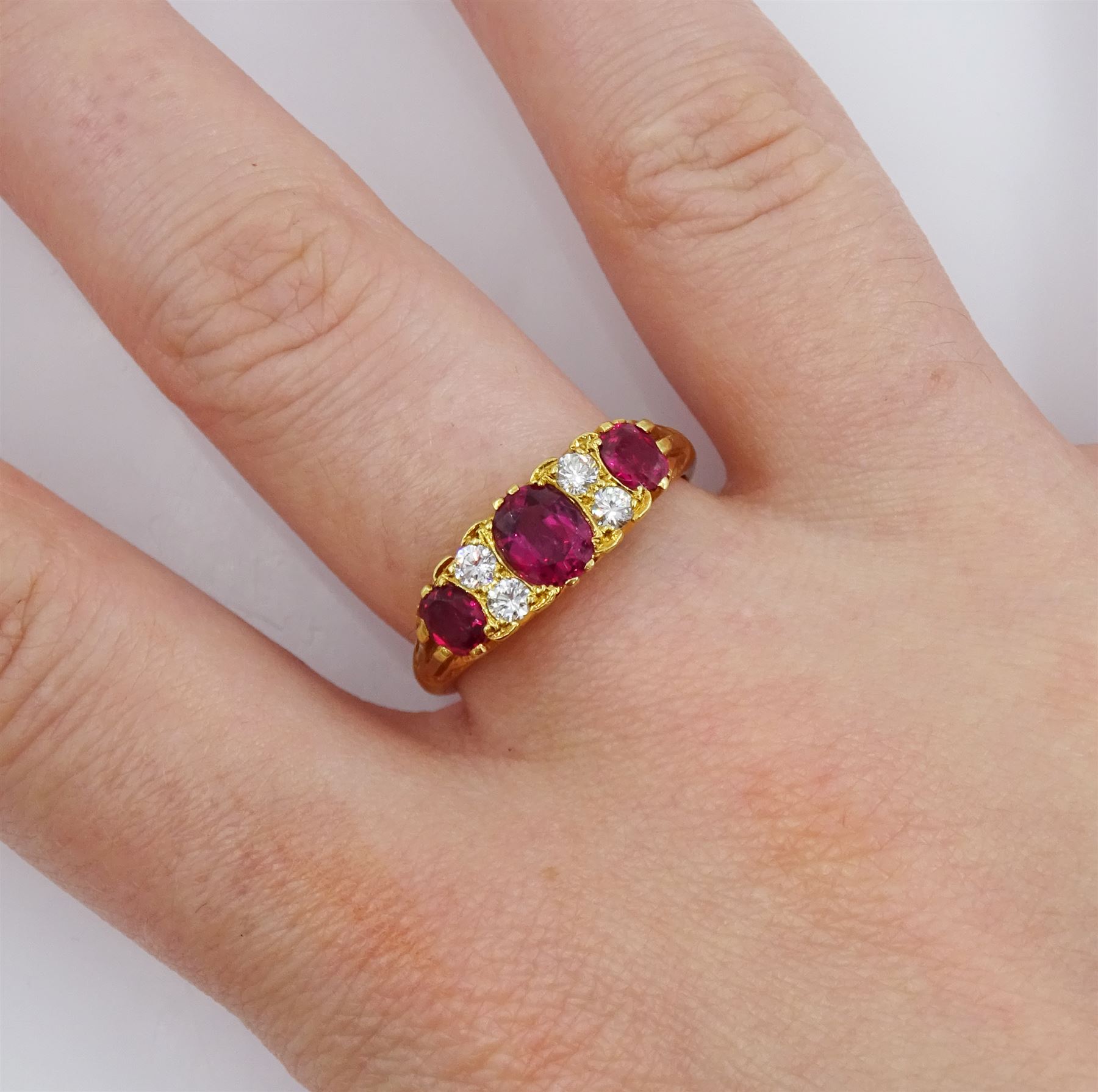 18ct gold three stone oval cut ruby and four stone round brilliant cut diamond ring, Birmingham 1972