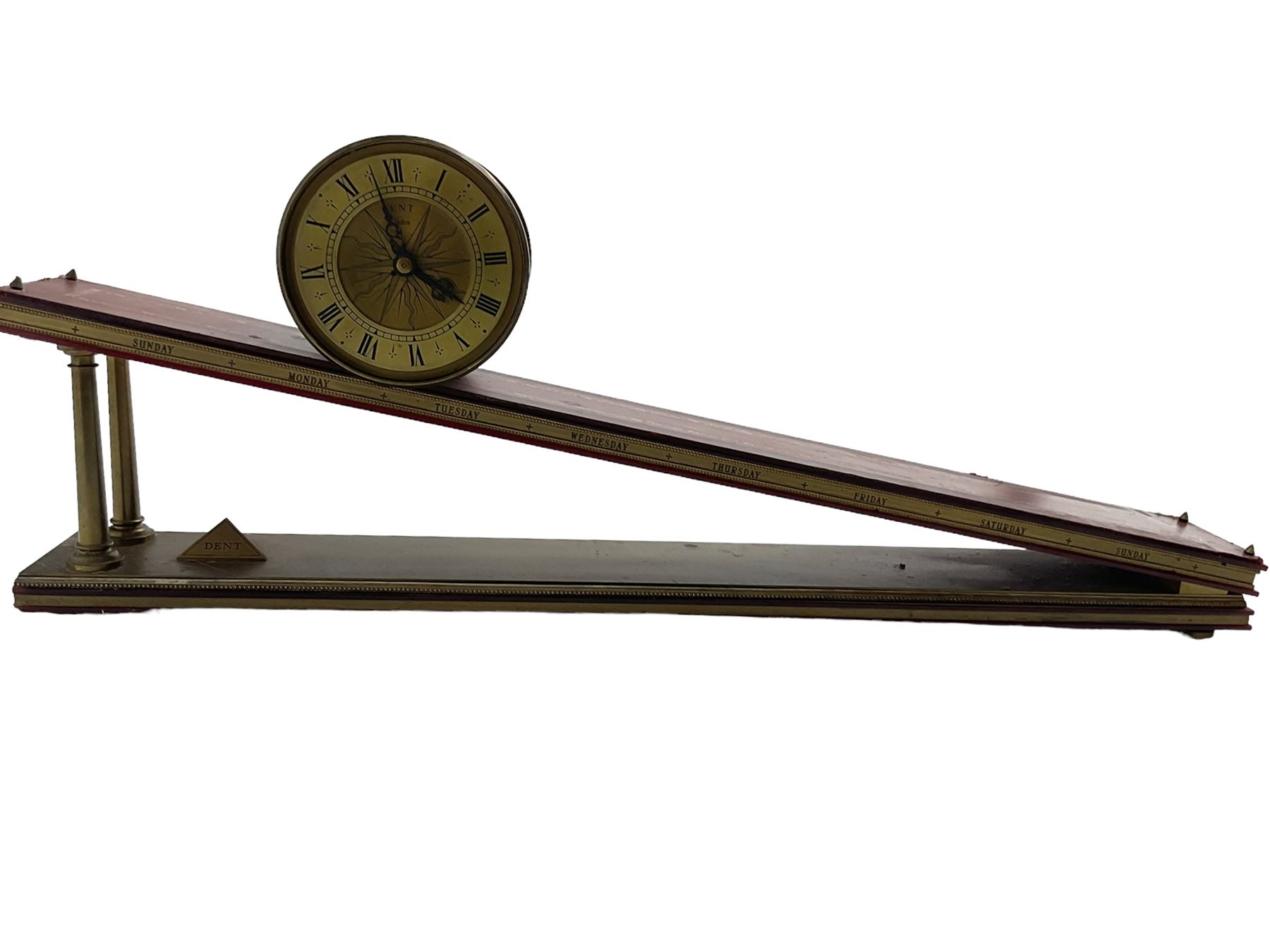 Dent incline plane clock, a 1970’s replica of a 17th century gravity clock manufactured by Dent of London in limited edition numbers, continuous lever balance movement driven with an internal counterweight, brass drum case with a gilt dial and silvered chapter ring, Roman numerals, engraved sunburst centre and pierced steel hands, inclined base with a red leather tooled top and the seven days of the week engraved to the front. With 500 limited edition certificate, No 154.