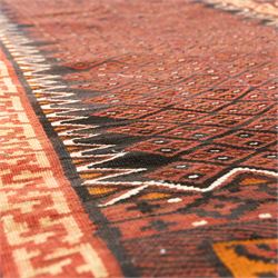 North west Persian Yamut Kilim, madder field with all-over lozenge lattice and serrated edges, with stepped end-panels and bold geometric borders in red, ivory and black