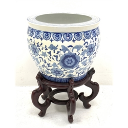 A large Chinese blue and white jardinière decorated with a band of flowers and tendrils within stylised borders, raised upon a hardwood stand, H53.5cm.