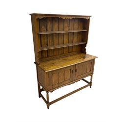 Early 20th century oak dresser, fitted with two cupboards and two-tier shelf plate rack, on turned supports united with box-stretcher