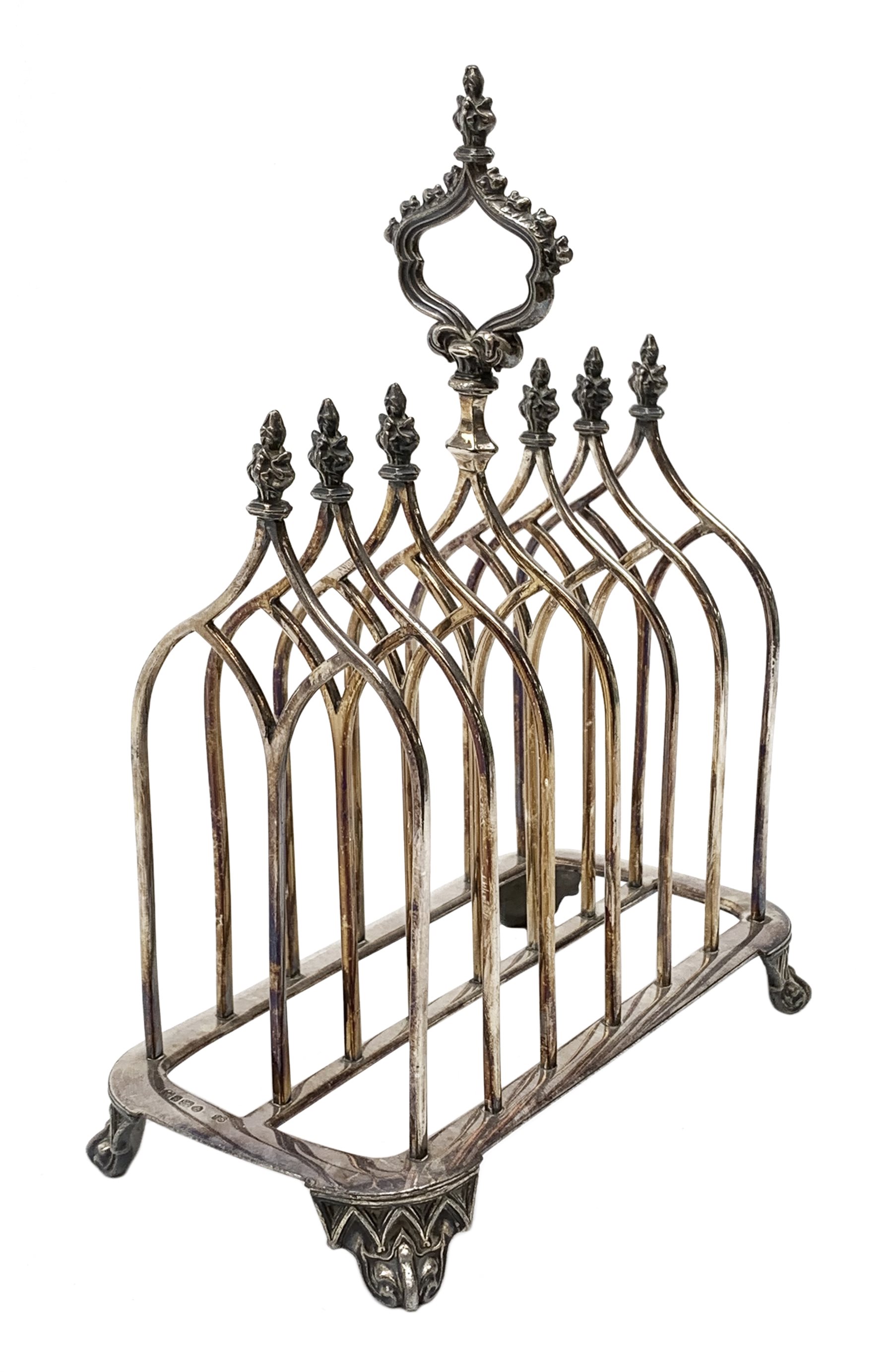 Victorian electroplate Gothic style toast rack, with seven arched bars, openwork handle and arcaded bracket feet, marks for John Gilbert, H25cm   